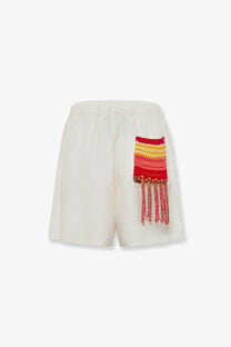 Laneus women’s cream viscose and linen blend Cancun Bermuda shorts with vibrant red and yellow hand-knitted patch tassels
