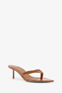 Le silla women’s gisele tan patent leather thong sandals with a slender heel shown from the back side