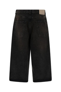 Our Legacy men’s green capri cut shorts shown from the back with black denim faded distressed finish and classic pockets