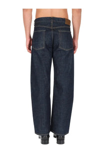 Our Legacy men’s jeans third cut blue dark indigo denim wide-leg jeans with brown leather patch at the waistband