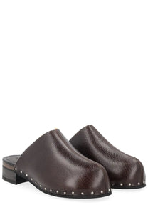 Brown leather clog shoes with silver studs along the edge from our legacy women’s sandal naoto black collection