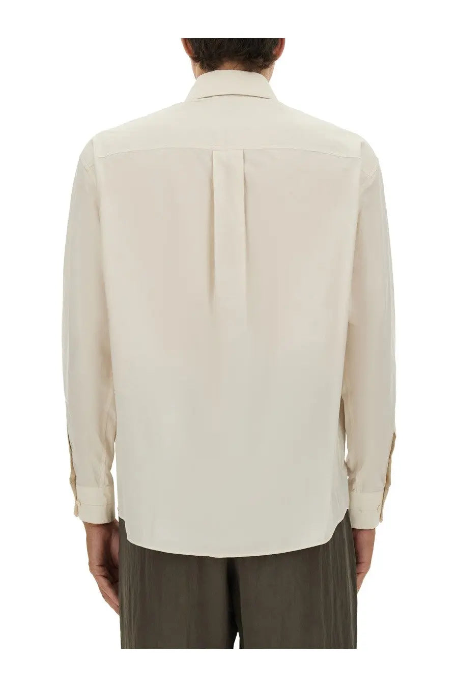 A cream-colored lemaire men’s cotton and silk shirt showing the back with a subtle pleat and folded cuffs