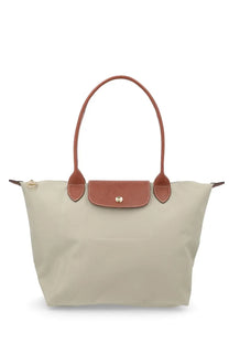 Beige Longchamp Le Pliage medium tote bag with tan leather handles and flap, ideal for everyday use