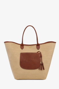Beige longchamp le panier pliage raffia tote bag with brown leather handles front pocket and tassel detail