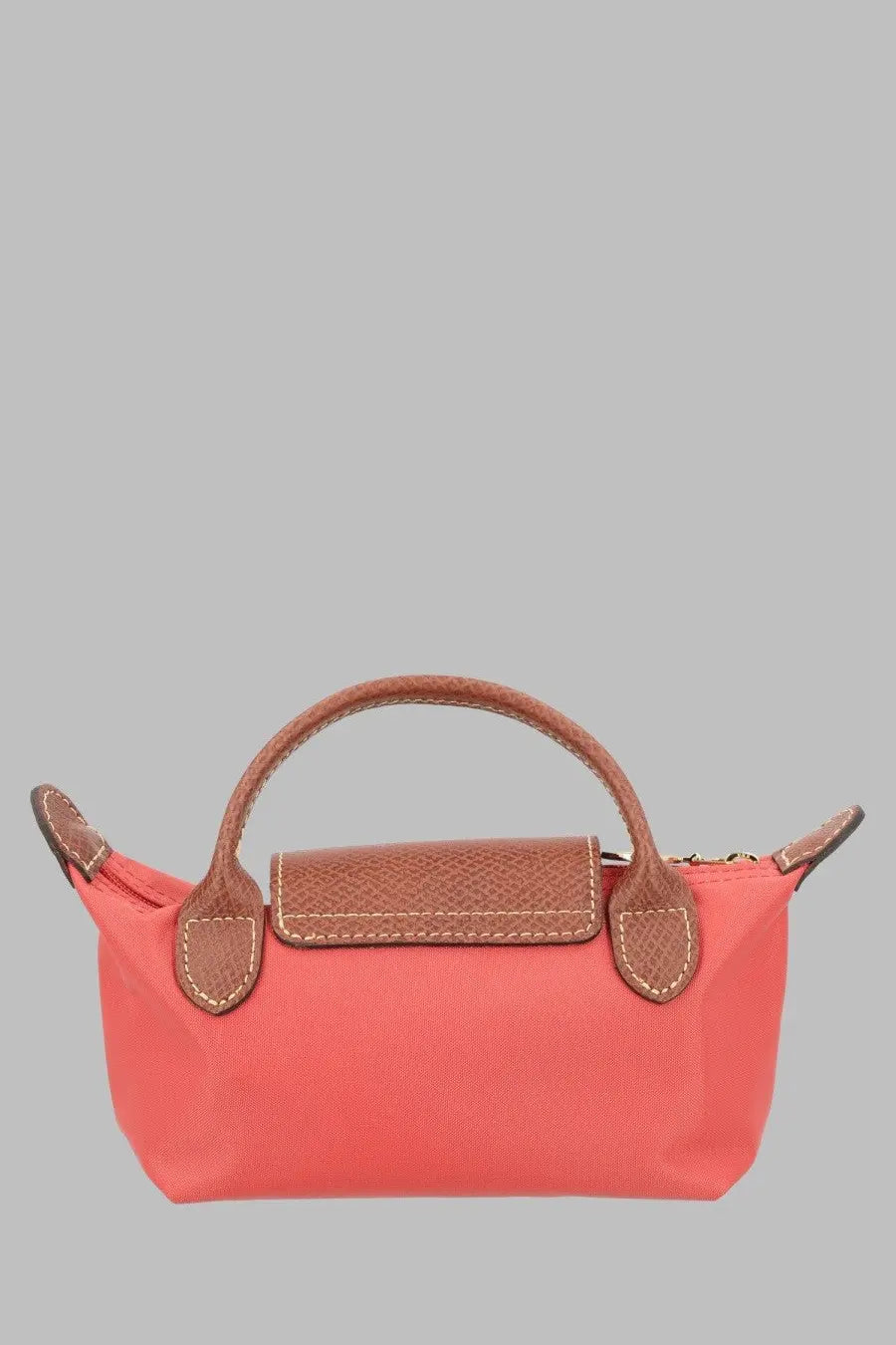 Coral-colored longchamp le pliage mini handbag with brown leather accents and handles in a women’s pochette style