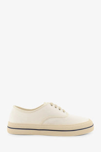 Loro Piana women’s cream canvas sneakers with beige rubber sole and black stitching along the edge