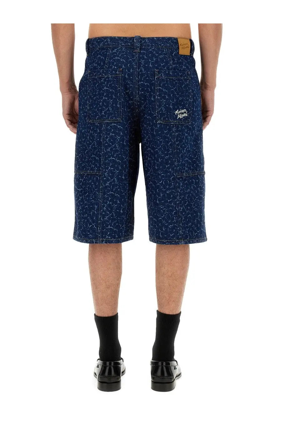Back view of maison kitsuné men’s blue denim bermuda shorts with white abstract pattern and alden embroidery