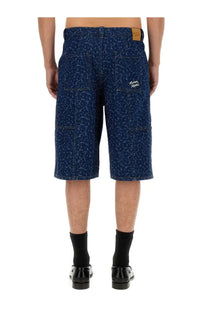 Back view of maison kitsuné men’s blue denim bermuda shorts with white abstract pattern and alden embroidery