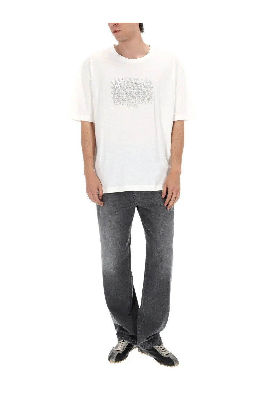 White oversized cotton t-shirt with subtle silver glittery chest graphic paired with maison margiela men’s black denim jeans