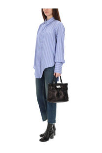 Black leather tote bag with tufted detailing and small rectangular label front paired with maison margiela blue cotton shirt