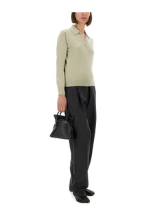 Black leather mini handbag with structured shape and top handles paired with maison margiela green polo shirt