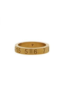 Gold-toned Maison Margiela women’s ring silver with engraved numbers along its gold band close-up view