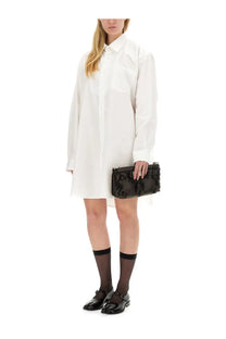 Black quilted leather clutch bag paired with maison margiela women’s white shirt dress front view