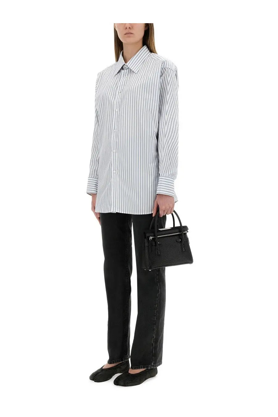 Black textured leather mini handbag with top handle and tassel details complementing maison margiela blue striped cotton shirt