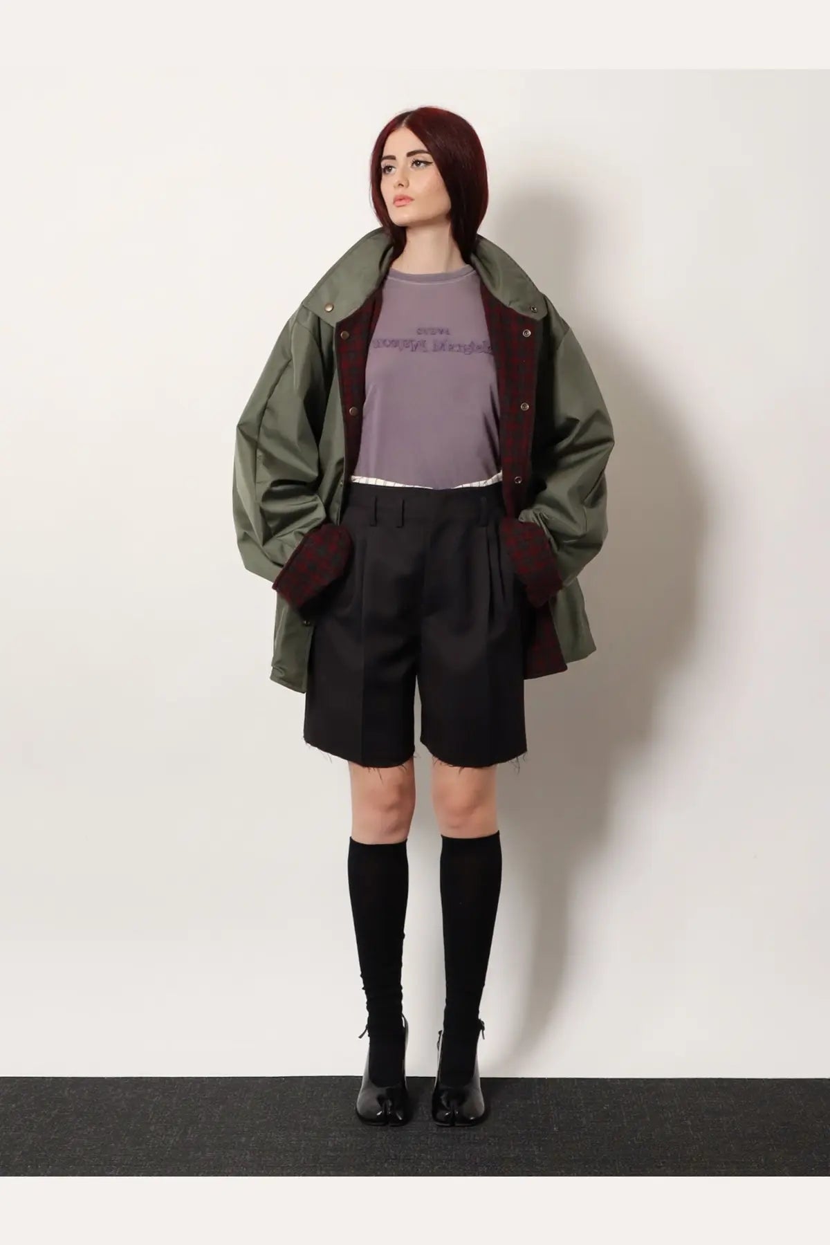 Olive green and maroon button-up field jacket with relaxed oversized fit paired with maison margiela black striped virgin wool shorts