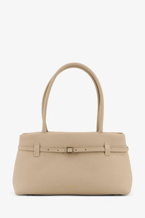 Beige leather shoulder bag by Manu Atelier with central buckle strap and curved top handles for women
