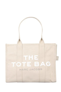 Beige canvas Marc Jacobs women’s borsa the tote large bag with white lettering and smaller gray branding below
