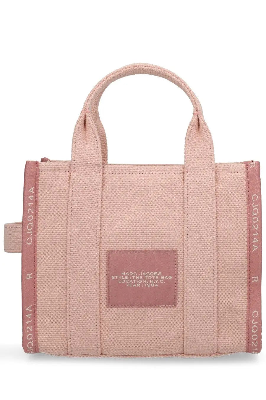 A blush pink canvas tote bag with matching handles and a rectangular leather patch embossed with marc jacobs text