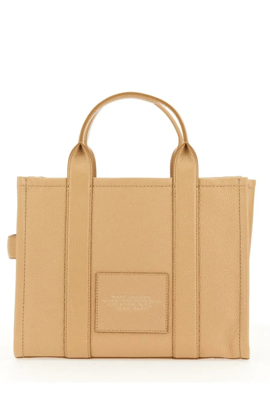 Beige leather tote bag by Marc Jacobs with top handles and a rectangular brand patch on the front