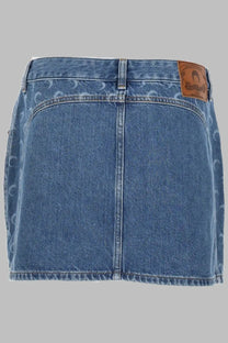 Back view of marine serre women’s blue denim mini skirt with subtle pattern and brown leather brand patch on waistband