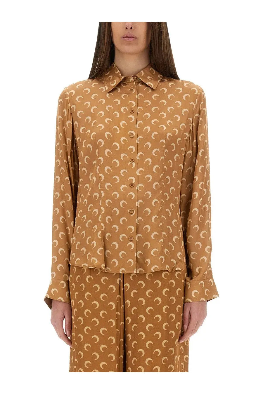 A woman wears a marine serre women’s moon satin shirt in beige with caramel color and cream crescent moon pattern