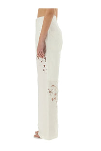 Marine Serre women’s upcycled linen white wide-leg pants with delicate brown floral embroidery on the lower legs