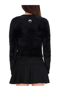 Back view of marine serre women’s black fuzzy long-sleeved sweater with circular silver emblem on the back