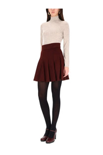 A flared high-waisted burgundy pleated skirt with fitted waistband paired with max mara women’s beige turtleneck sweater