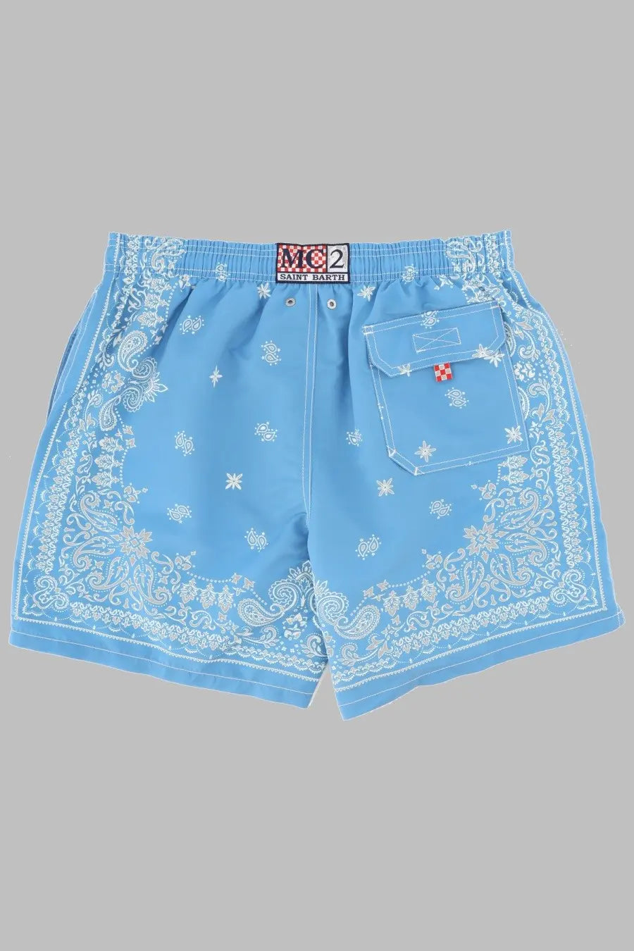 Light blue Mc2 Saint Barth men’s swim trunks with white bandana paisley floral print and red cross patch on pocket