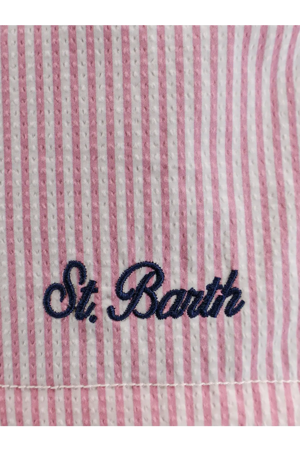Pink and white striped mesh fabric with navy blue embroidered st on mc2 saint barth men’s patmos swim trunks