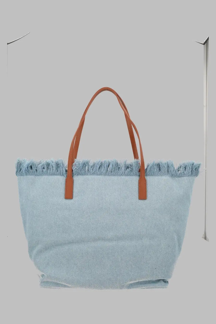 Light blue denim tote bag with brown leather handles and frayed top edge by Mc2 Saint Barth