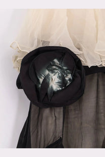 A black fabric rose brooch with a glossy reflective center on mes demoiselles women’s belvy long viscose dress black