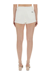 Michael Kors women’s white denim shorts showing the back with frayed hem and embroidered logo on right pocket