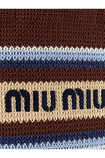 Beige and brown striped crocheted miu miu bag strap with navy blue embroidered branding on a brown knitted shopping bag
