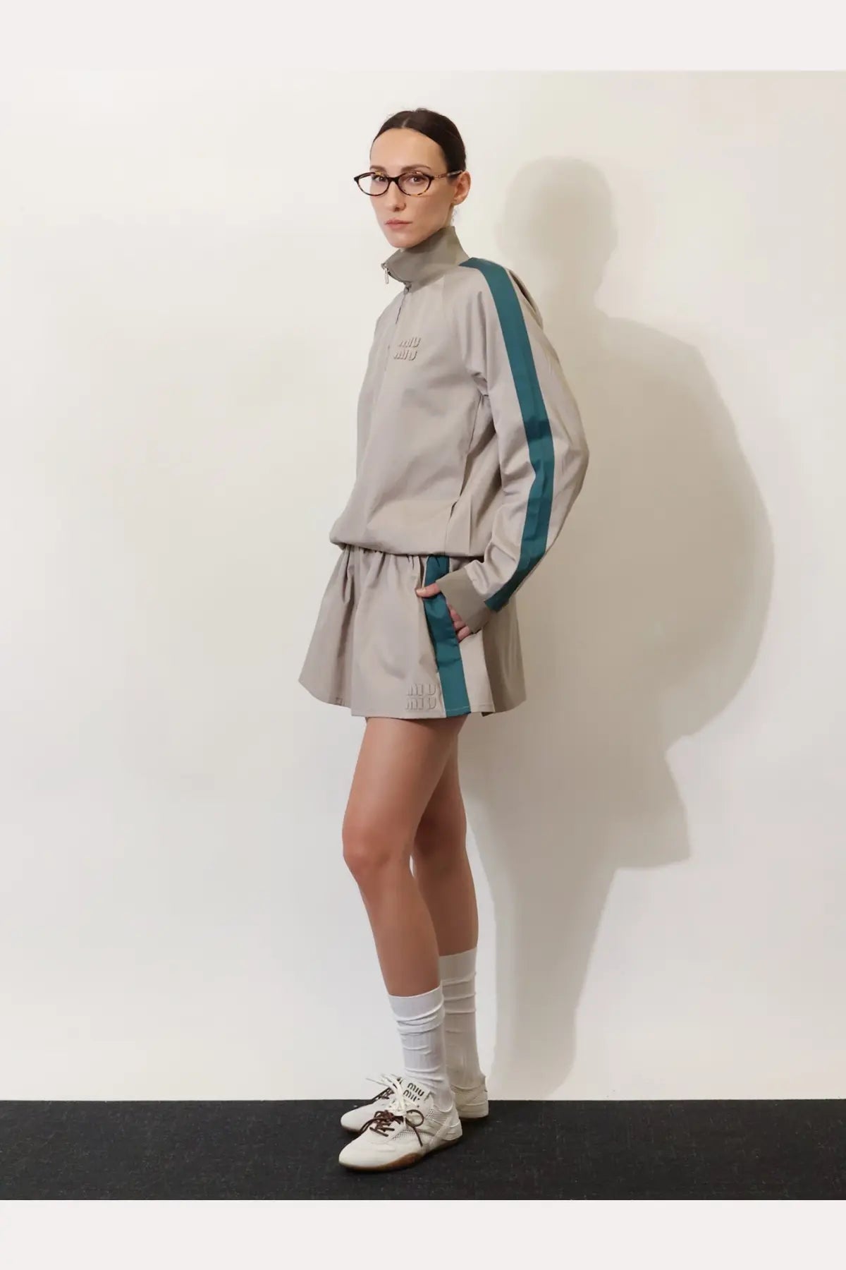 Miu miu women’s old twill jacket green featuring a gray athletic tracksuit set with teal stripes and high collar details