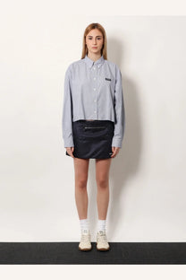 Miu Miu women’s pin check cotton shirt in blue features light blue and white vertical stripes with a black logo patch