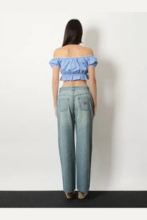 Light-wash denim jeans with relaxed wide-leg cut and subtle distressing paired with miu miu blue striped cotton top