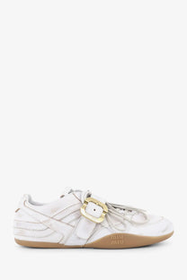 Miu miu women’s white leather sneakers with gold-tone buckle and tan rubber sole showing used effect