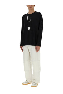 Black long-sleeved cotton top with white graphic print paired with mm6 maison margiela men’s white cotton canvas pants