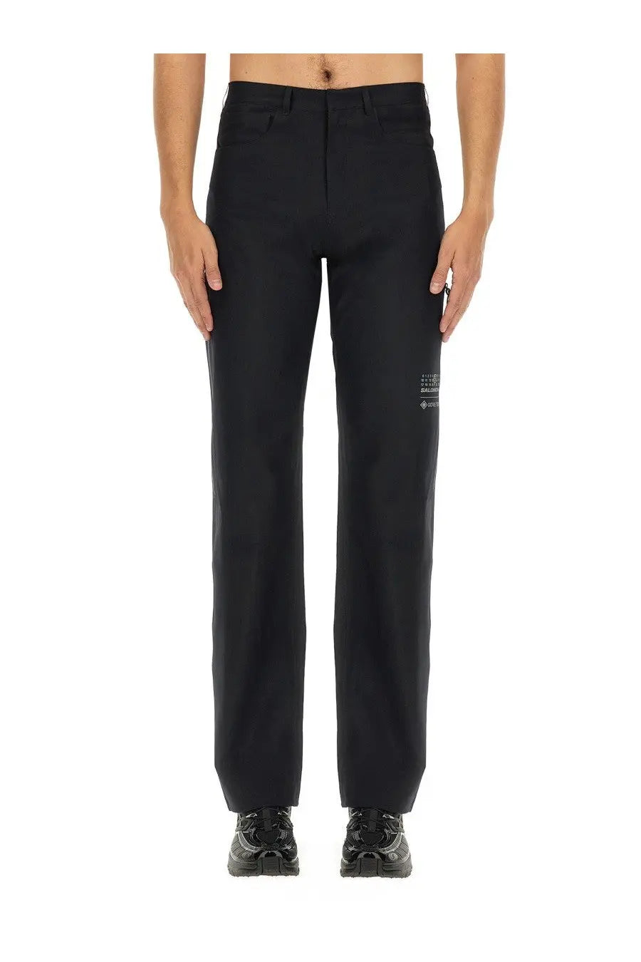 Mm6 Maison Margiela men’s straight leg black trousers with a subtle white logo patch on the lower leg