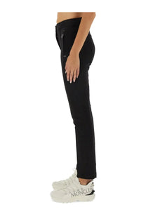 Black moncler grenoble women’s slim-fit pants with a sleek tapered design and subtle side zippers