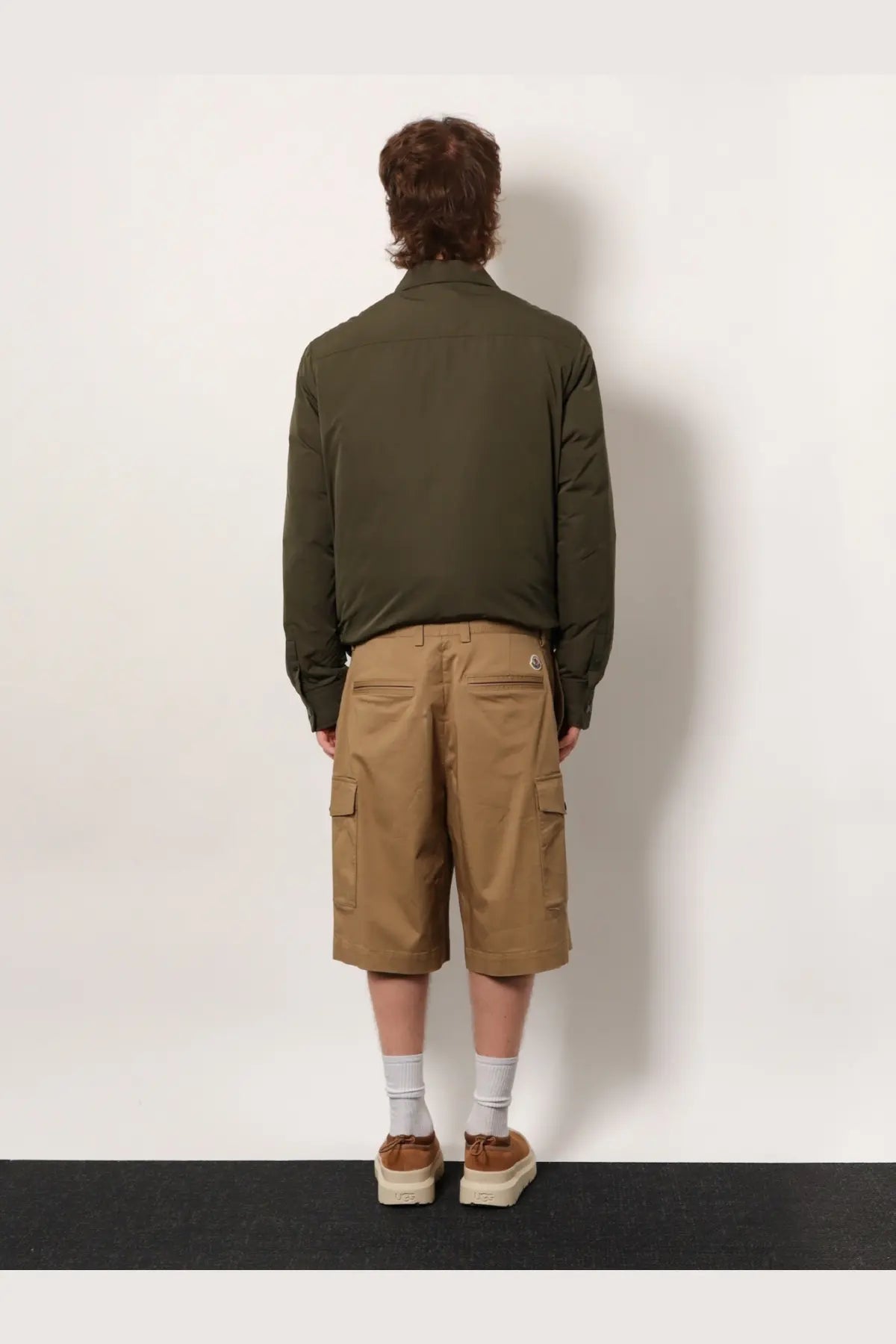 Olive green quilted jacket with long sleeves and collar paired with moncler men’s beige cargo cotton shorts