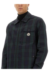Moncler men’s checked cotton gabarine shirt jacket in dark green and black plaid with a white logo patch on the chest pocket