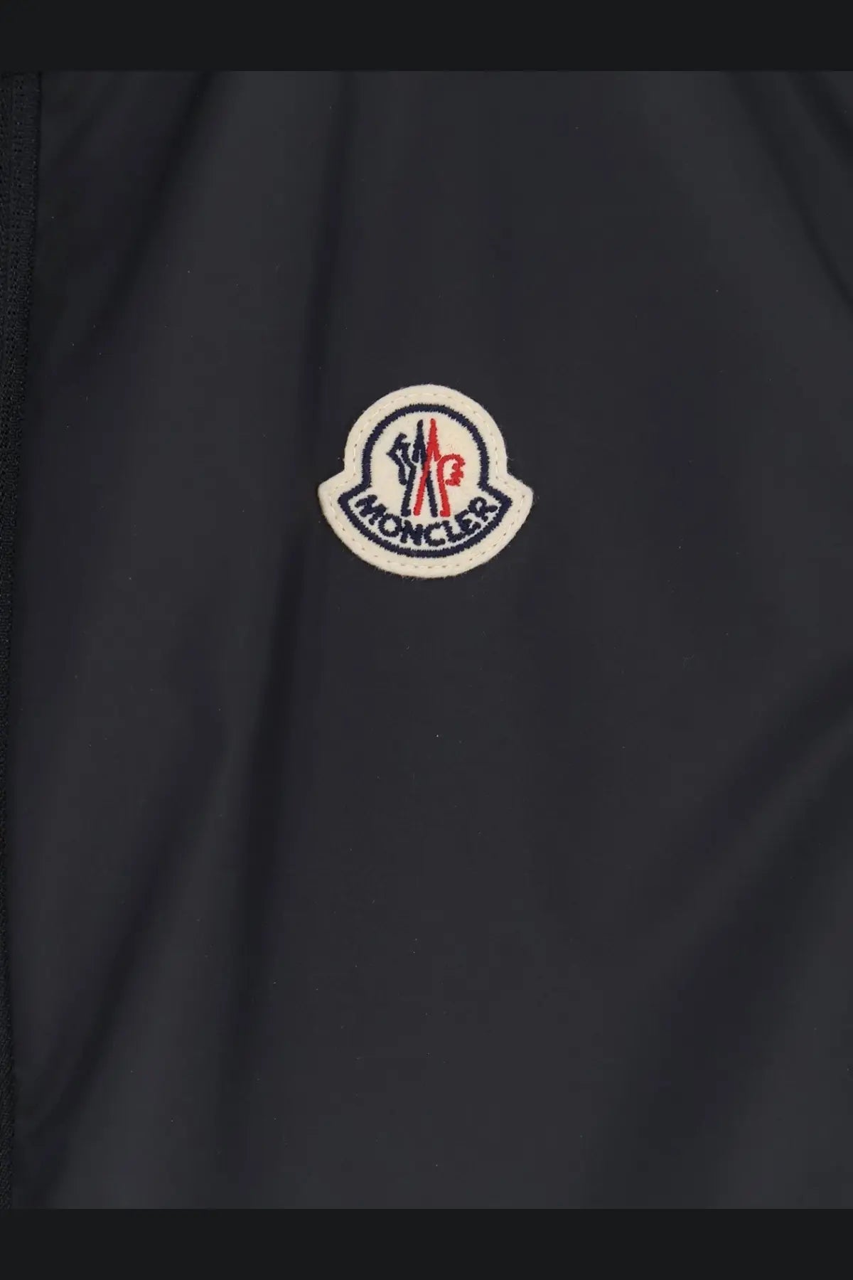 Dark gray moncler men’s hemmoor jacket featuring circular embroidered logo with red white and navy blue accents