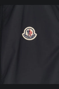Dark gray moncler men’s hemmoor jacket featuring circular embroidered logo with red white and navy blue accents