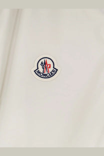 White moncler logo patch with embroidered red blue and black details on light fabric of mens hemmoor jacket white