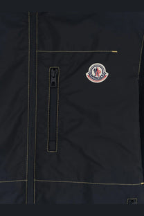 Moncler men’s black nylon jacket with yellow stitching and circular logo patch on the chest