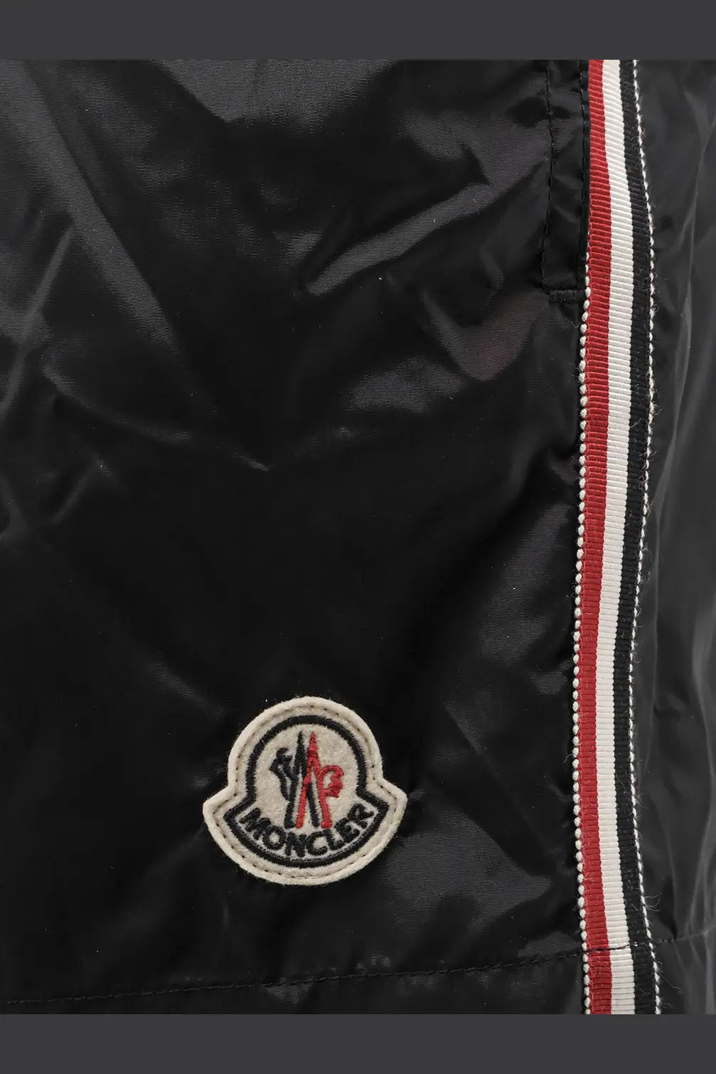 Black moncler men’s nylon puffer jacket with circular embroidered logo and red white black striped zipper tape