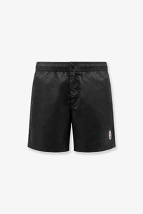 Moncler men’s black nylon swim trunks with a subtle sheen and small embroidered logo on the lower right leg