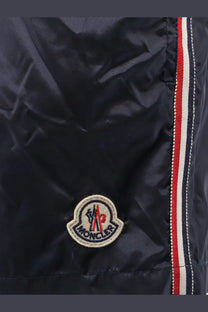 Moncler men’s dark navy nylon jacket with circular embroidered logo and red white blue striped seam detail